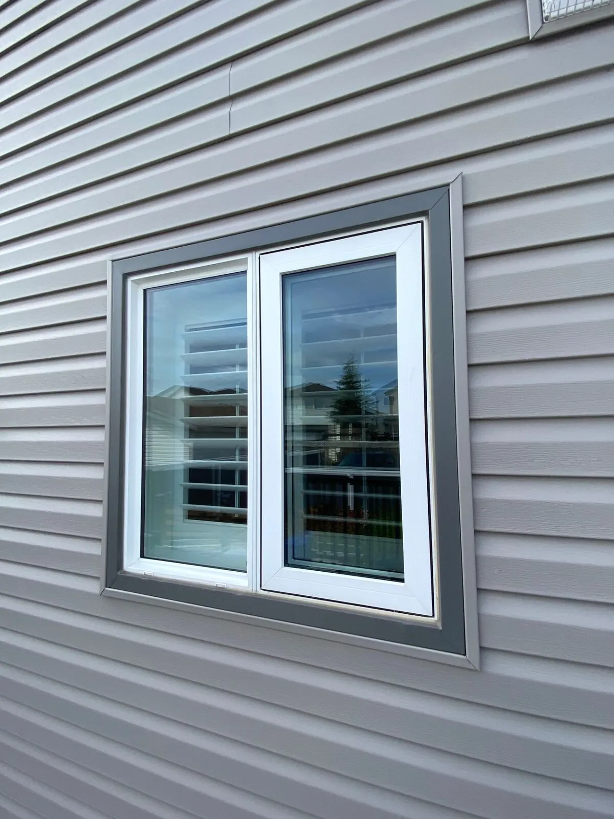 White vinyl casement window with grey trim